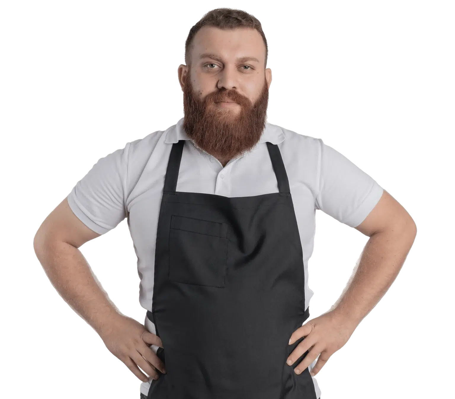 A professional bearded barber man in an apron, standing confidently against a white wall.