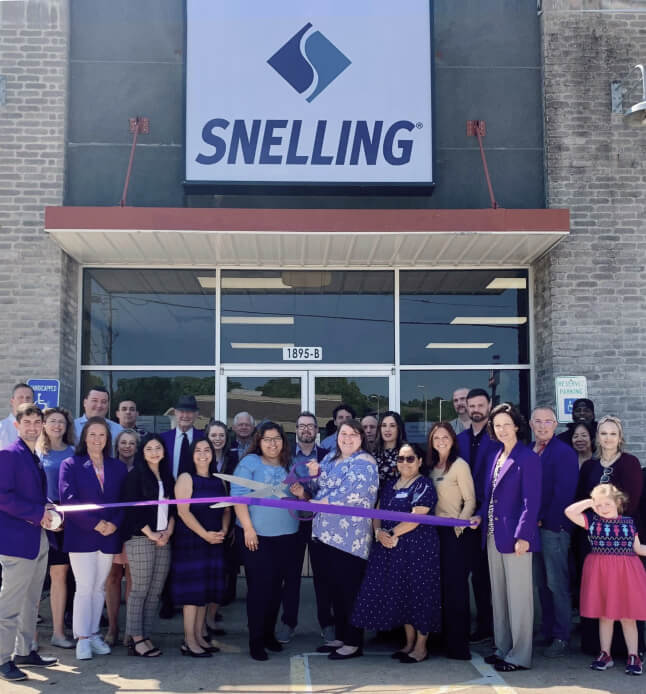 A group of people stands outside the Snelling office.